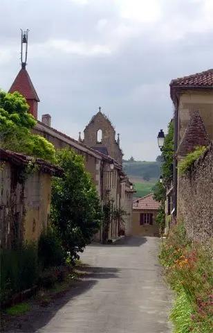 Ruelle du village bordée de maisons anciennes vers l’église